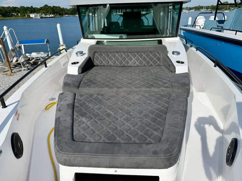 Slide: The Image of 2019 Axopar AX37XC boat with cushioned seating, docked by a serene waterfront. - 8