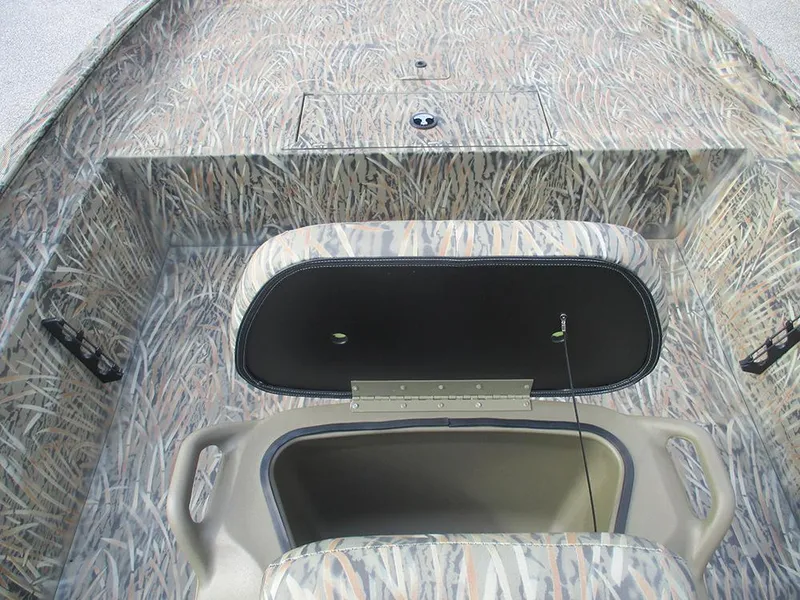 Slide: The Image of 2026 Tracker Grizzly 1860 CC boat interior with camo design and open storage compartment. - 13