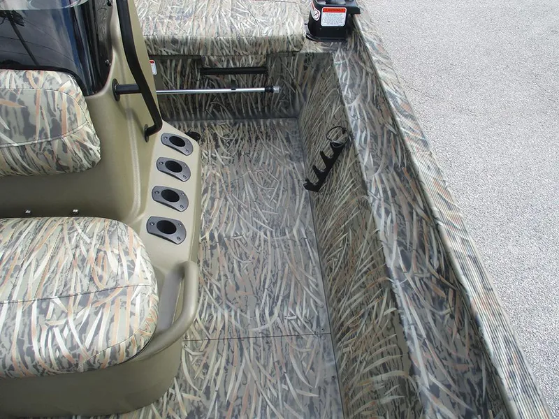 Slide: The Image of 2026 Tracker Grizzly 1860 CC boat interior with camouflage seating and rod holders. - 14