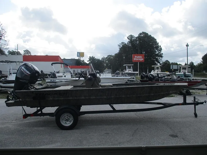 Slide: The Image of 2026 Tracker Grizzly 1860 CC boat on trailer, parked outdoors near storage facility. - 4