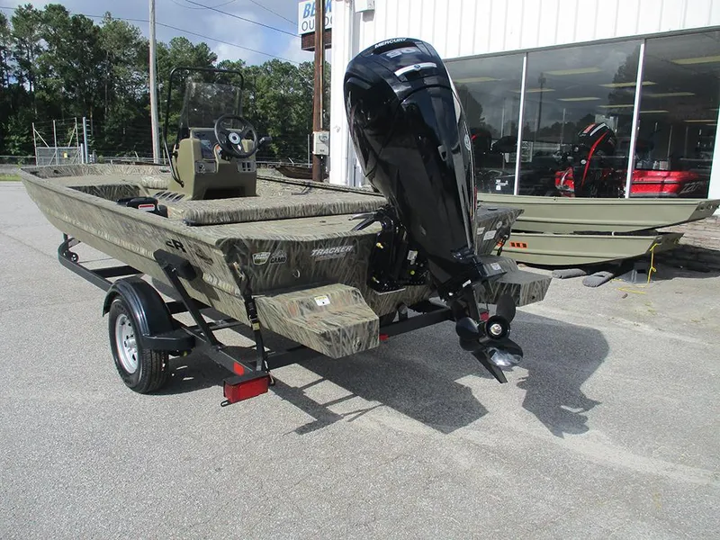 Slide: The Image of 2026 Tracker Grizzly 1860 CC boat with outboard motor on trailer, parked outdoors. - 8