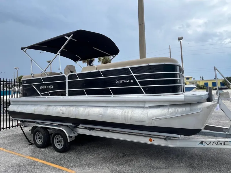 Slide: The Image of 2022 Godfrey Sweetwater 2286 FS pontoon boat on trailer, parked outdoors. - 1