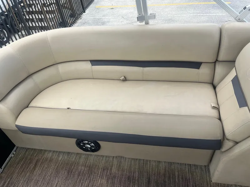 Slide: The Image of 2022 Godfrey Sweetwater 2286 FS boat interior with beige seating and speaker. - 11