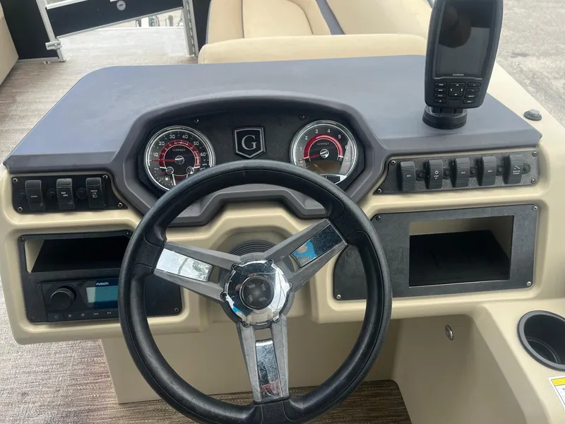 Slide: The Image of Steering console of 2022 Godfrey Sweetwater 2286 FS boat with gauges and controls. - 6