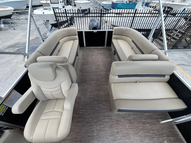 Slide: The Image of 2022 Godfrey Sweetwater 2286 FS pontoon boat interior with beige seating and helm chair. - 7