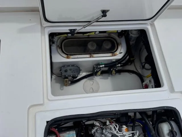 Slide: The Image of 2021 Contender 39 Fisharound boat compartment with open hatch, showcasing internal components. - 14