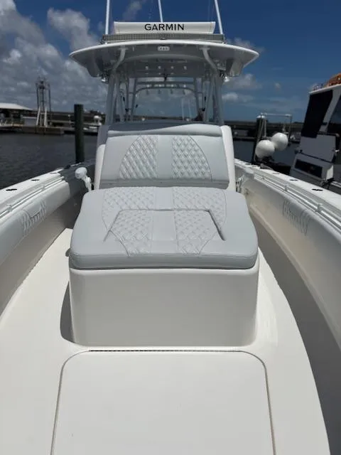 Slide: The Image of 2021 Contender 39 Fisharound boat with cushioned seating and Garmin equipment, docked under a clear sky. - 15