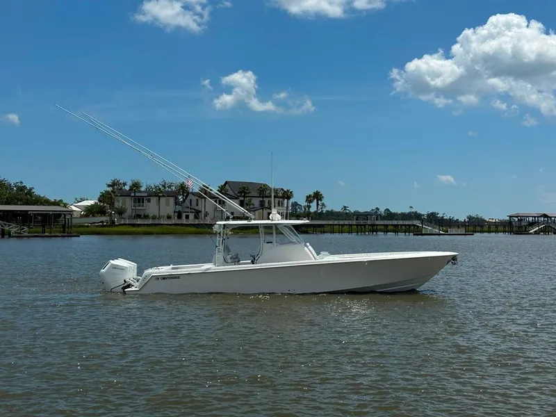 Slide: The Image of 2021 Contender 39 Fisharound boat on calm water under a clear blue sky. - 4