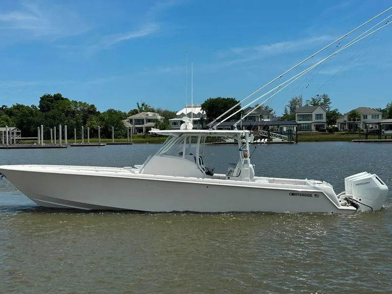 Slide: The Image of 2021 Contender 39 Fisharound boat on calm water, with a clear blue sky background. - 5