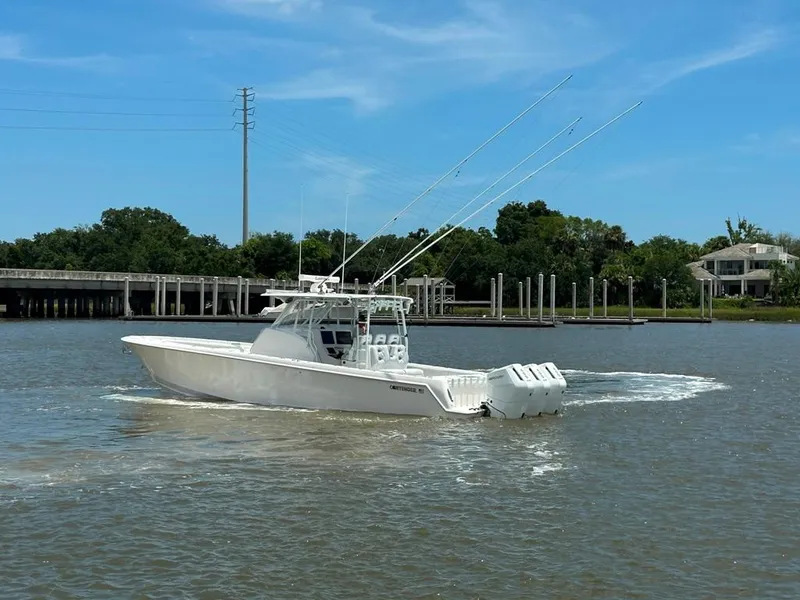 Slide: The Image of 2021 Contender 39 Fisharound boat cruising on a sunny day near a dock. - 7