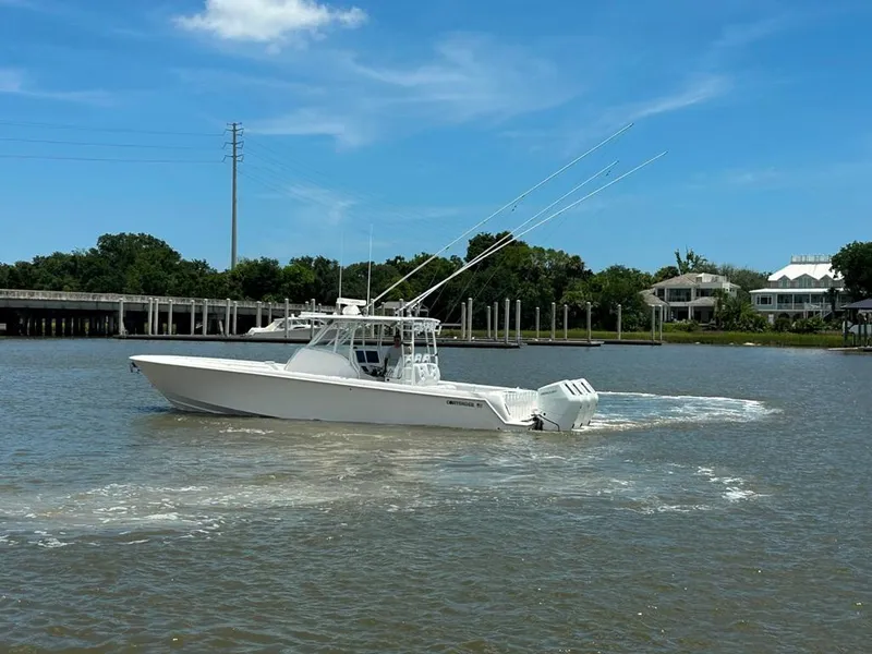 Slide: The Image of 2021 Contender 39 Fisharound boat cruising on a sunny day near a bridge. - 8