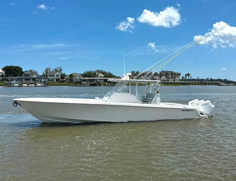 Slide: The Image of 2021 Contender 39 Fisharound boat on calm water under clear blue sky. - 9