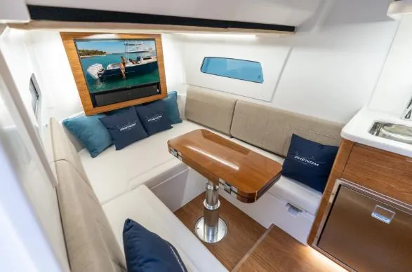 Slide: The Image of Luxurious interior of 2026 Phenom 43 Center Console with elegant seating and wooden table. - 6
