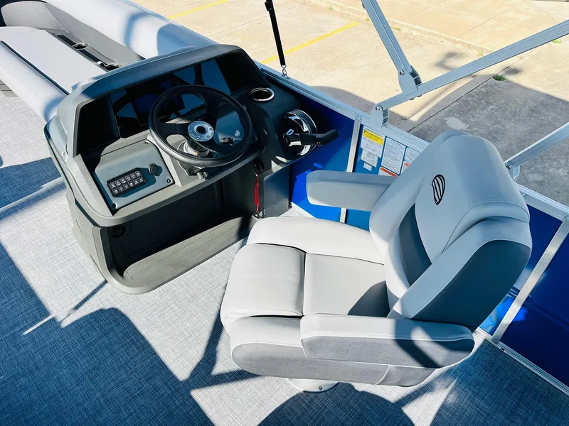 Slide: The Image of 2026 Sun Tracker Party Barge 18 DLX helm with steering wheel and captain's chair. - 25