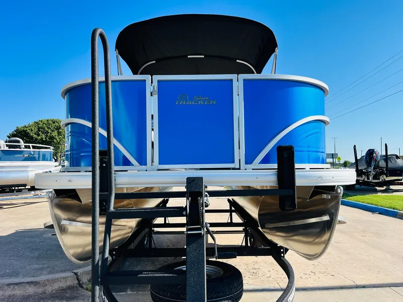 Slide: The Image of 2026 Sun Tracker Party Barge 18 DLX pontoon boat, blue exterior, parked on trailer. - 3