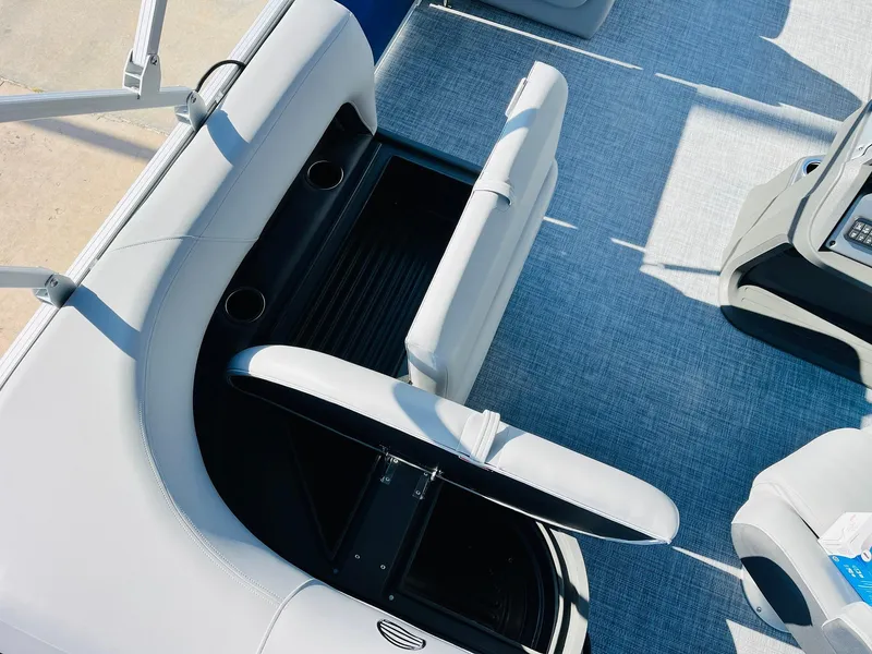 Slide: The Image of 2026 Sun Tracker Party Barge 18 DLX interior with open storage compartment and cup holders. - 30