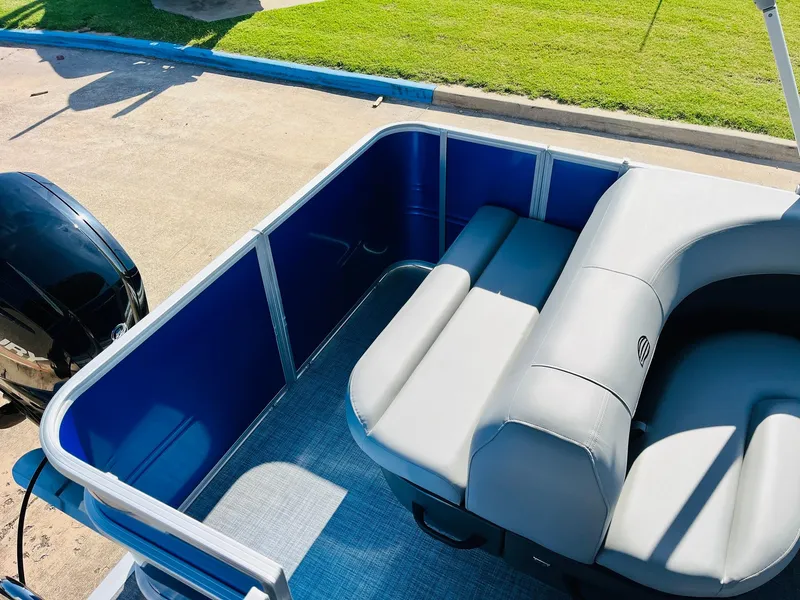 Slide: The Image of 2026 Sun Tracker Party Barge 18 DLX interior with blue panels and gray seating. - 31