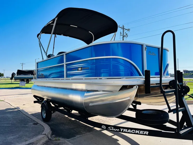 Slide: The Image of 2026 Sun Tracker Party Barge 18 DLX pontoon boat on trailer, sunny day. - 4