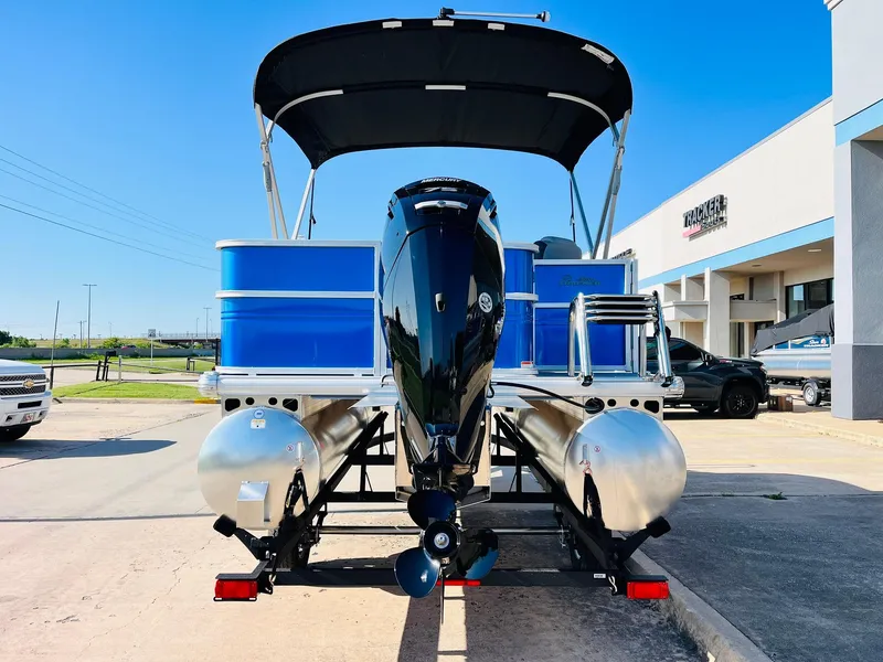 Slide: The Image of 2026 Sun Tracker Party Barge 18 DLX pontoon boat with outboard motor, parked outdoors. - 7