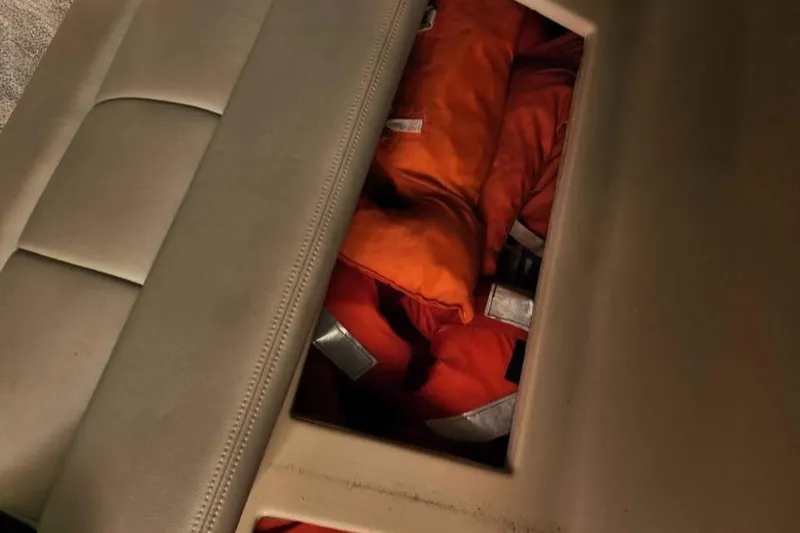 Slide: The Image of Storage compartment with orange life jackets on a 2005 Rampage 30 Express boat. - 18