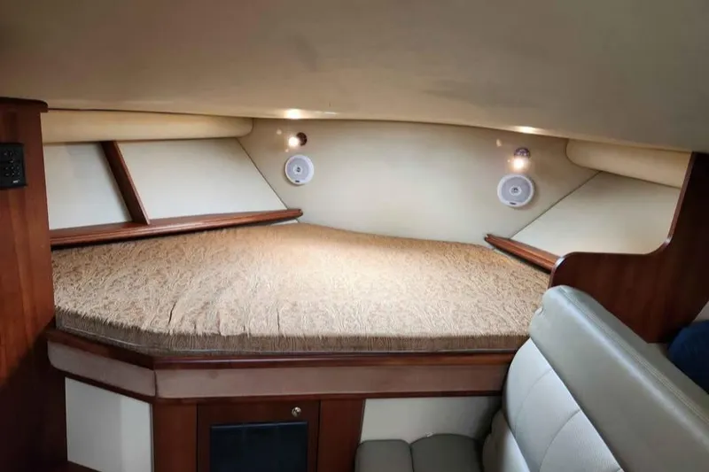 Slide: The Image of 2005 Rampage 30 Express cabin interior with cozy bed and wooden accents. - 22