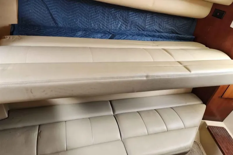 Slide: The Image of Interior seating of a 2005 Rampage 30 Express boat, featuring beige upholstery. - 23