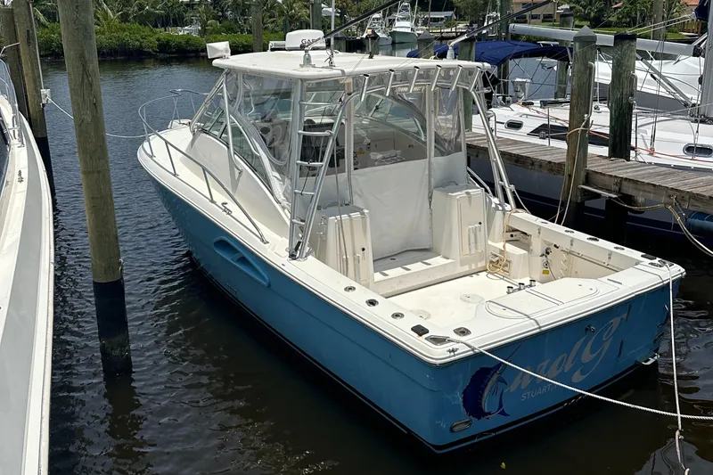 Slide: The Image of 2005 Rampage 30 Express boat docked in a marina, featuring a blue hull and spacious deck. - 3