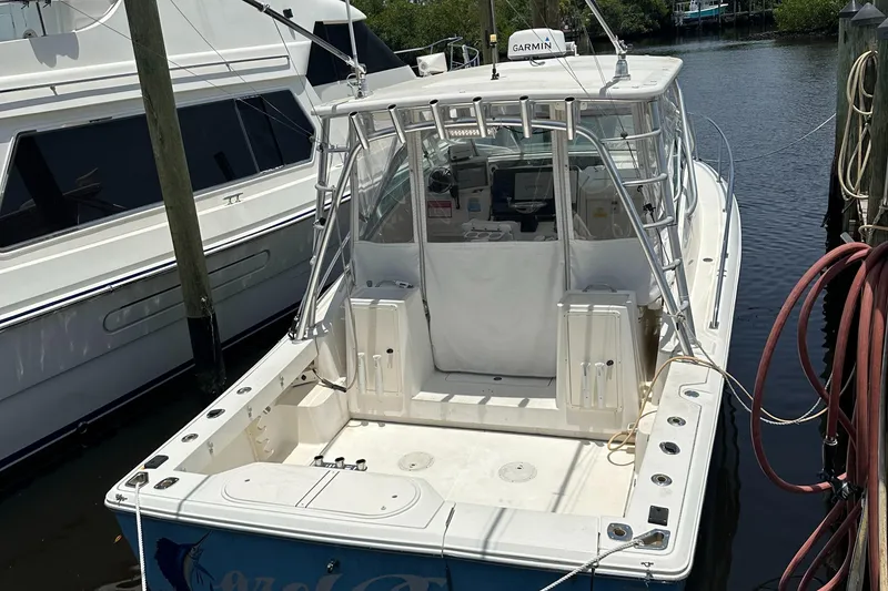 Slide: The Image of 2005 Rampage 30 Express boat docked, featuring spacious deck and Garmin equipment. - 4