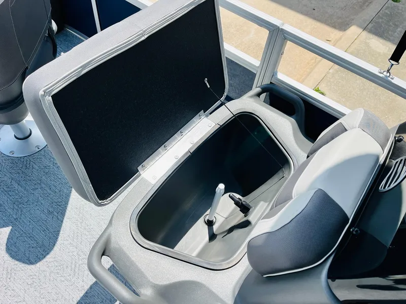 Slide: The Image of 2026 Sun Tracker Bass Buggy 18 DLX boat seat storage compartment open, showing interior details. - 19