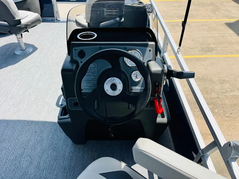 Slide: The Image of 2026 Sun Tracker Bass Buggy 18 DLX steering console with gauges and seating. - 22