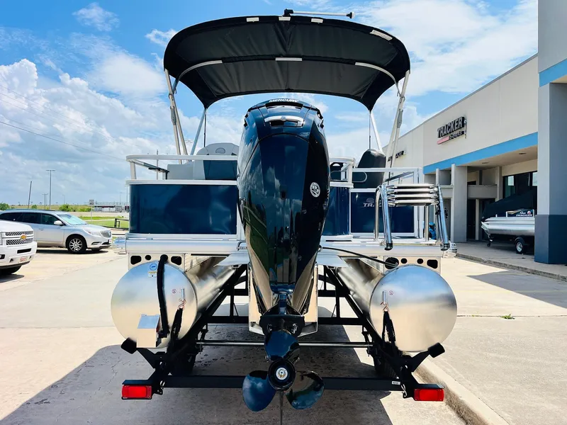 Slide: The Image of 2026 Sun Tracker Bass Buggy 18 DLX pontoon boat with canopy, parked outdoors. - 7