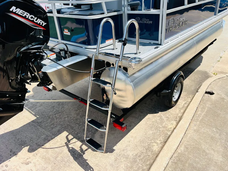 Slide: The Image of 2026 Sun Tracker Bass Buggy 18 DLX pontoon boat with Mercury engine and boarding ladder. - 9