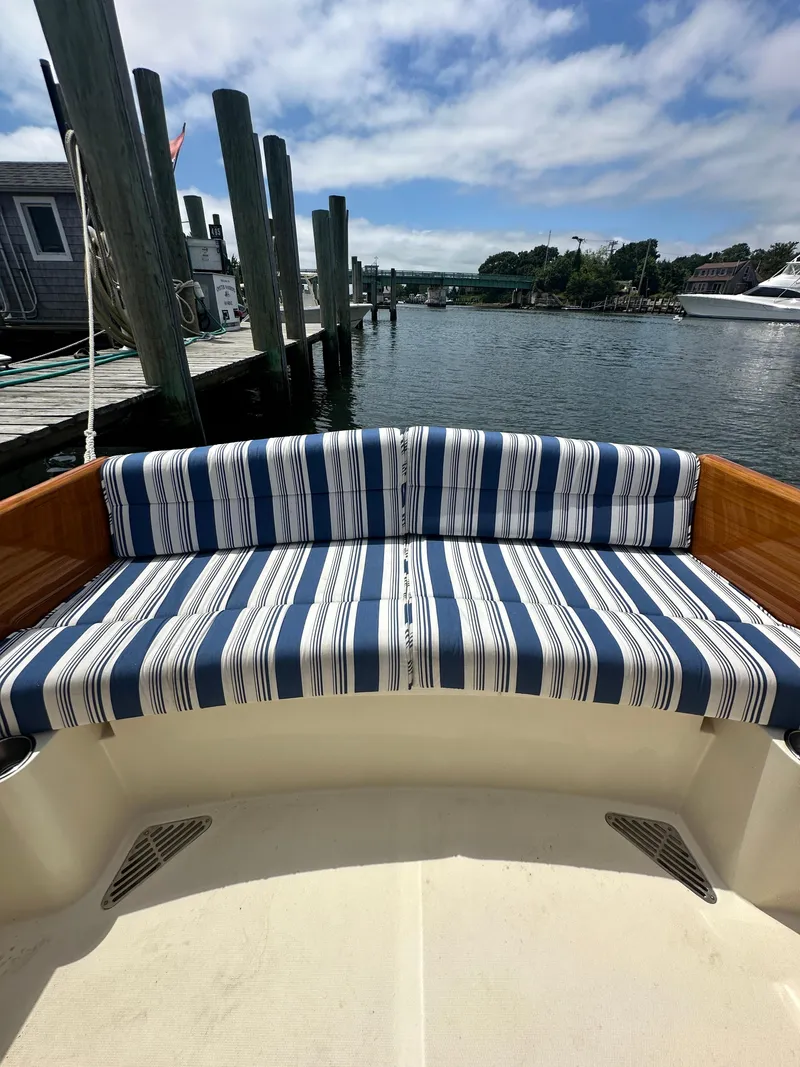 Slide: The Image of Hinckley 36 boat with striped seating, docked by a serene waterfront, 2005 model. - 21
