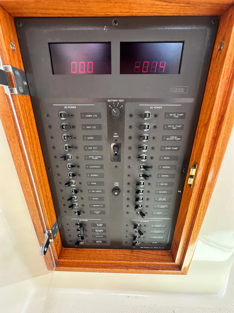 Slide: The Image of Electrical control panel of a 2005 Hinckley 36 boat with switches and digital displays. - 28