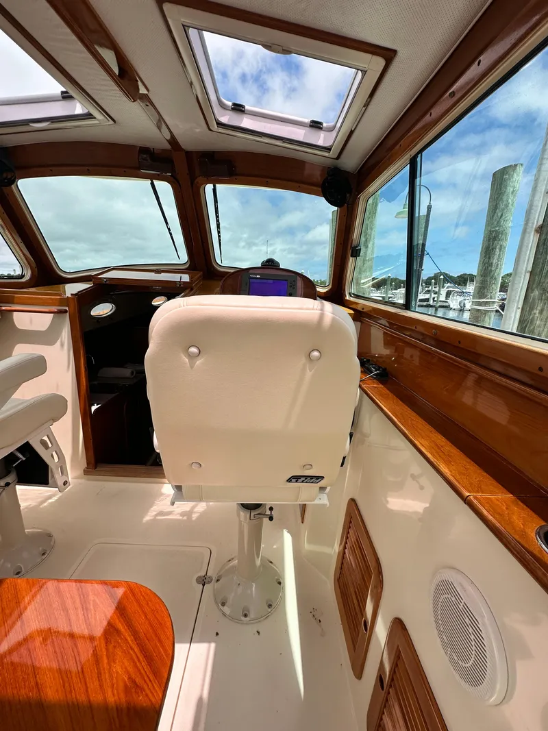Slide: The Image of Interior of a 2005 Hinckley 36 boat, featuring a helm seat and wooden accents. - 31