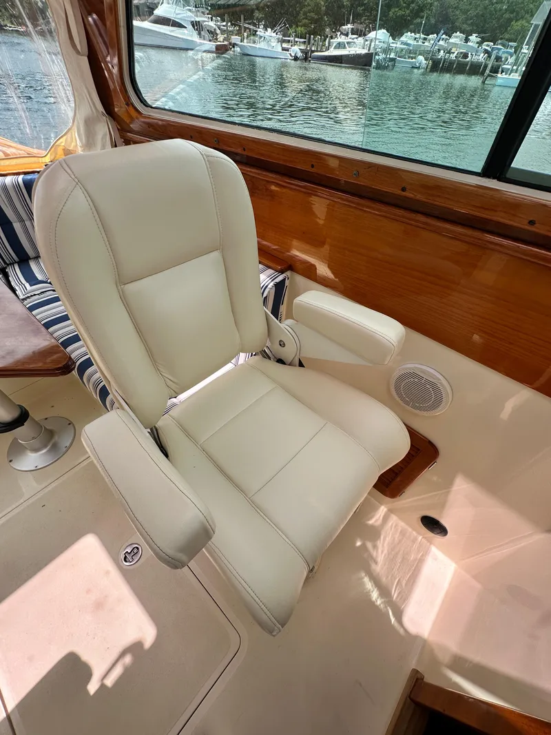 Slide: The Image of Luxury seating on a 2005 Hinckley 36 yacht, with a scenic marina view. - 32