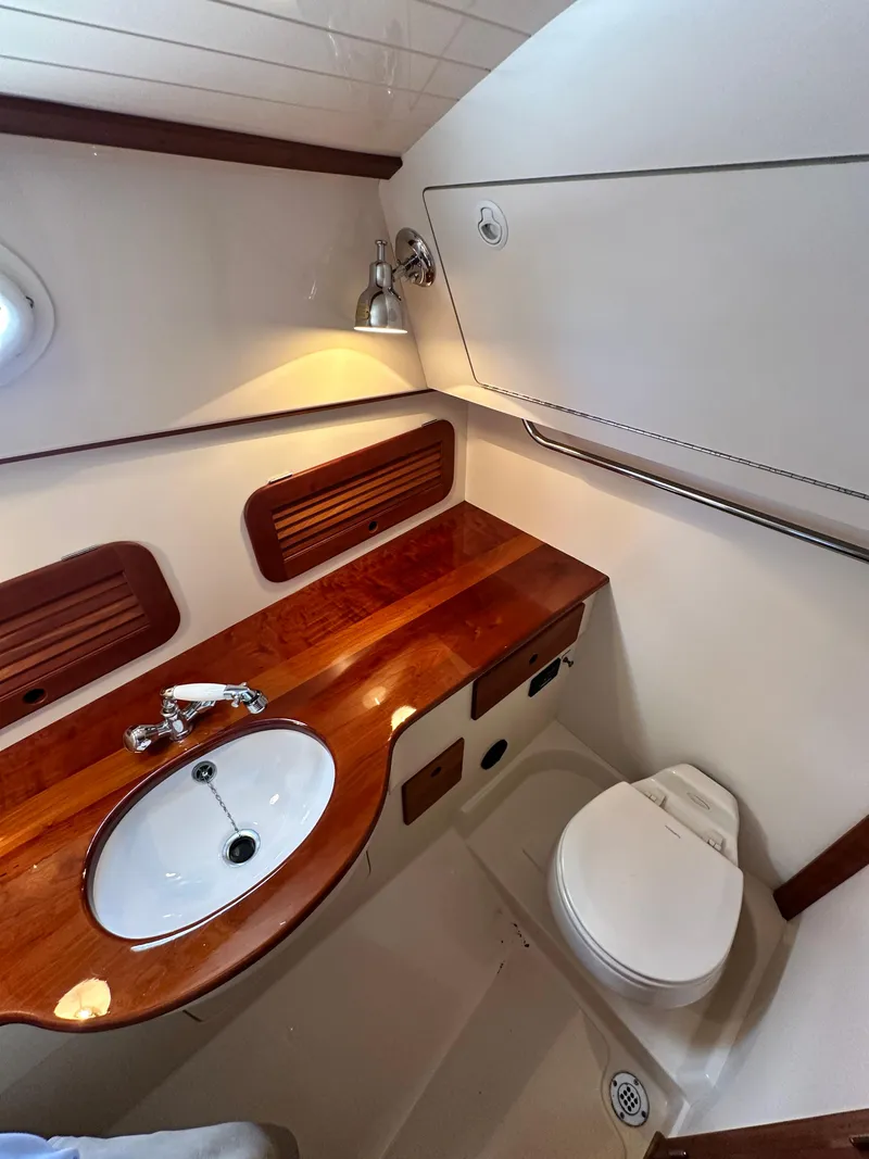 Slide: The Image of 2005 Hinckley 36 yacht bathroom with wooden countertop, sink, and toilet. - 37