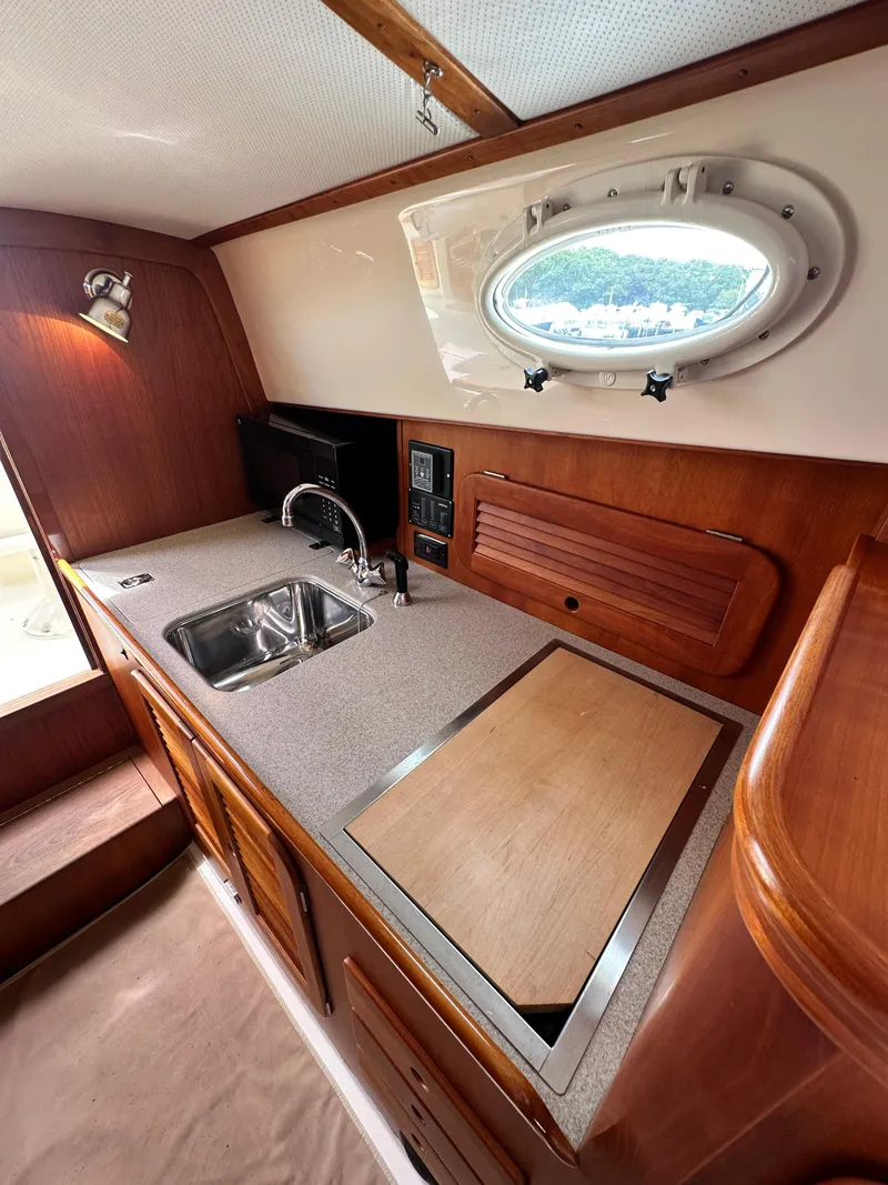 Slide: The Image of Hinckley 36 yacht interior kitchen with sink, countertop, and porthole window, 2005 model. - 42