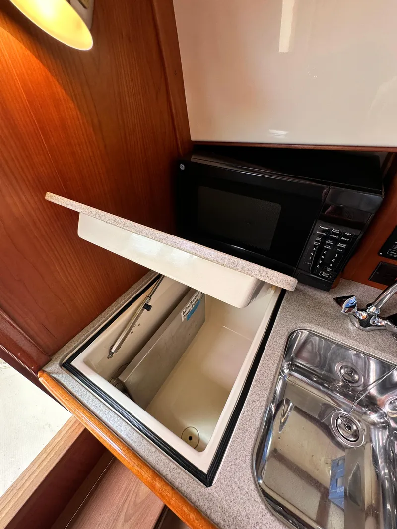 Slide: The Image of Hinckley 36 yacht kitchen with sink, microwave, and storage, 2005 model. - 43