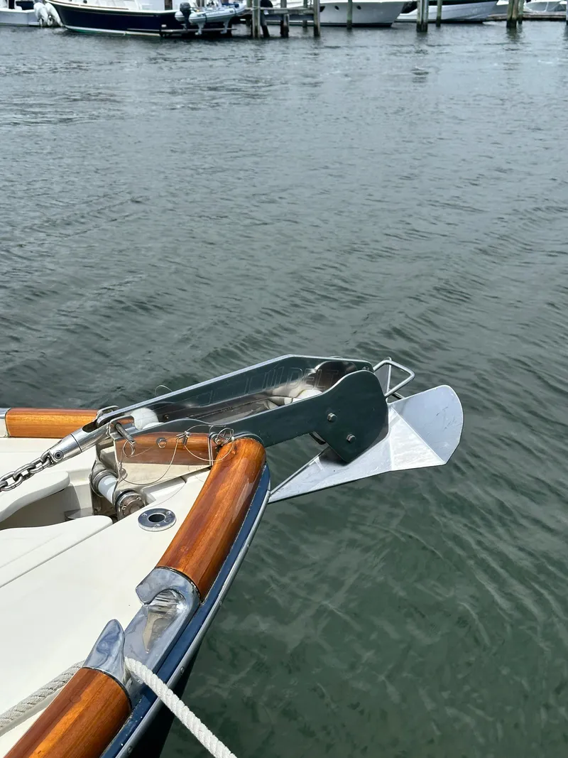 Slide: The Image of Bow of a 2005 Hinckley 36 boat with anchor, docked on calm water. - 46