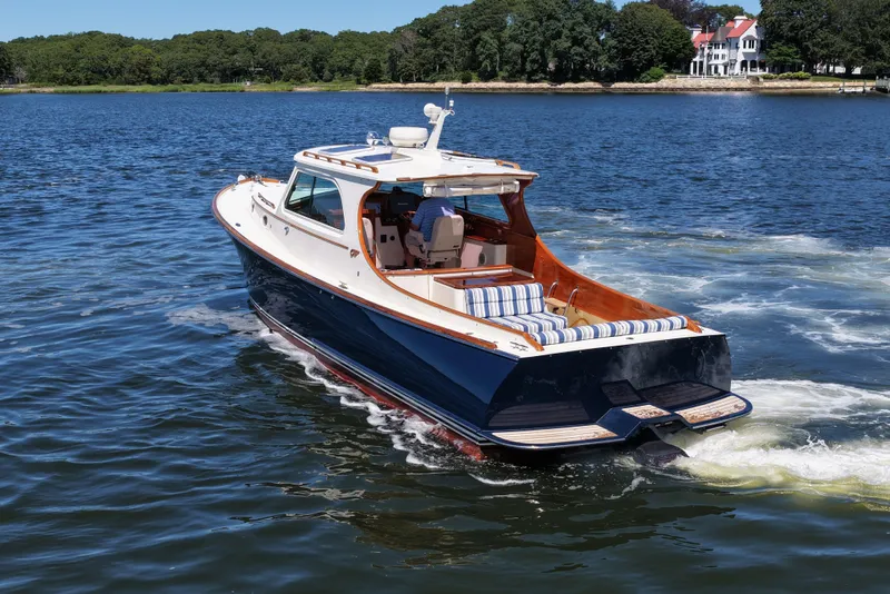 Slide: The Image of Hinckley 36 boat cruising on a lake, 2005 model, with scenic shoreline in background. - 6