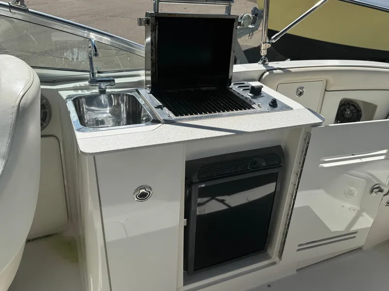 Slide: The Image of 2008 Sea Ray 290 Sundeck boat kitchenette with sink, grill, and storage. - 5
