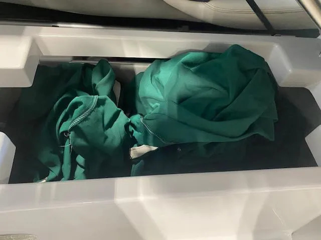 Slide: The Image of Storage compartment in a 2000 Four Winns 210 Horizon boat with green fabric inside. - 15