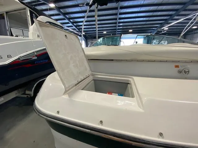 Slide: The Image of 2000 Four Winns 210 Horizon boat with open storage compartment in a showroom. - 5