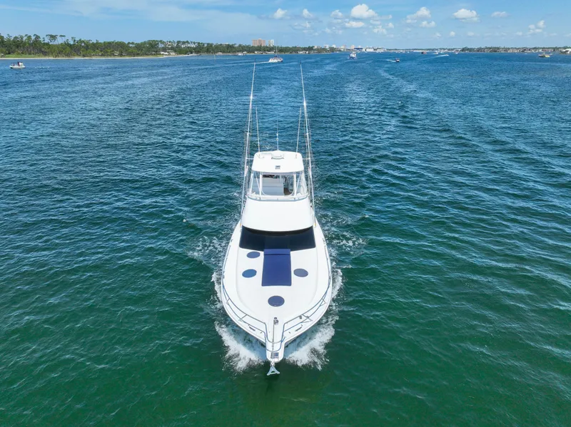 Slide: The Image of 2007 Riviera 42 Flybridge yacht cruising on open water under a clear blue sky. - 1