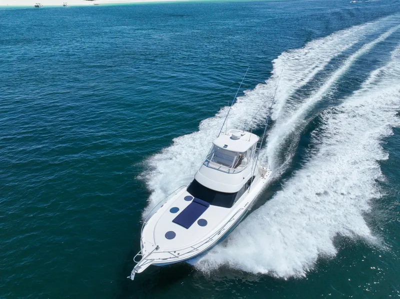 Slide: The Image of 2007 Riviera 42 Flybridge yacht cruising on open blue water. - 10