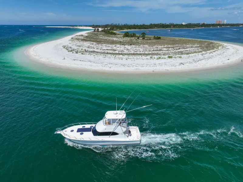 Slide: The Image of 2007 Riviera 42 Flybridge cruising near a sandy island with turquoise waters. - 14