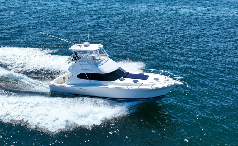 Slide: The Image of 2007 Riviera 42 Flybridge yacht cruising on open water, creating a wake. - 18