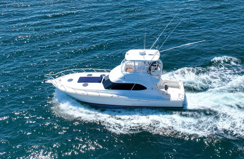 Slide: The Image of 2007 Riviera 42 Flybridge yacht cruising on open blue waters. - 19