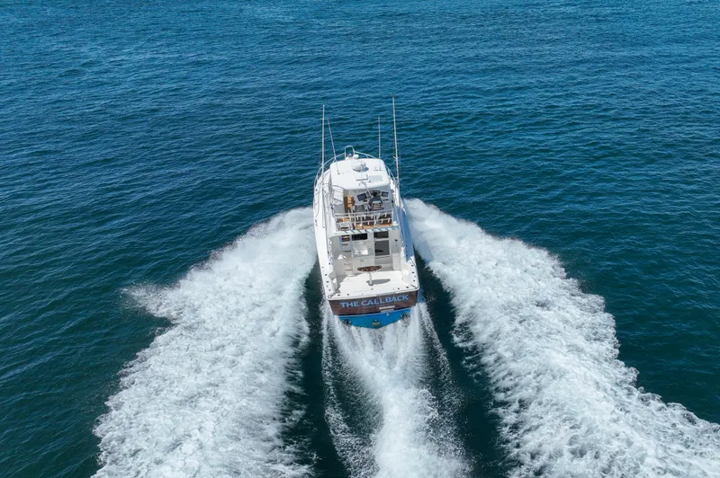 Slide: The Image of 2007 Riviera 42 Flybridge yacht cruising on open water, creating a wake. - 20